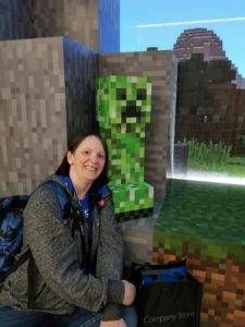 Sadukie in the Microsoft Visitors Center, sitting in the Minecraft area, next to an acacia tree and creeper