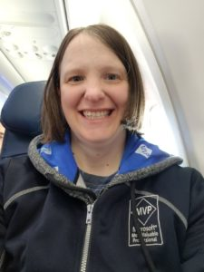 Sadukie, sitting in her plane seat and wearing her Microsoft MVP hoodie